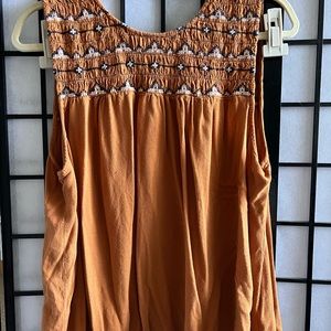Nice sleeveless blouse brown color with blue. Button is broken on back.